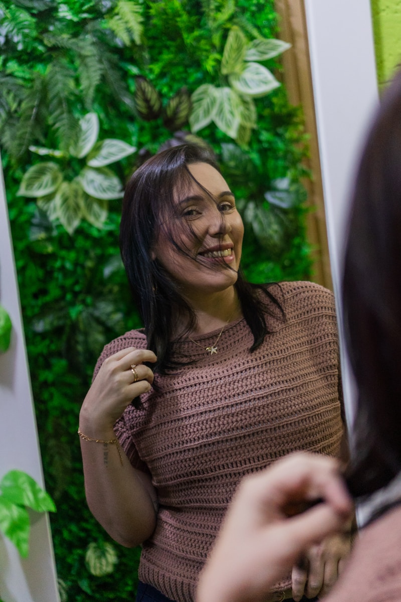 A smiling woman looks in the mirror